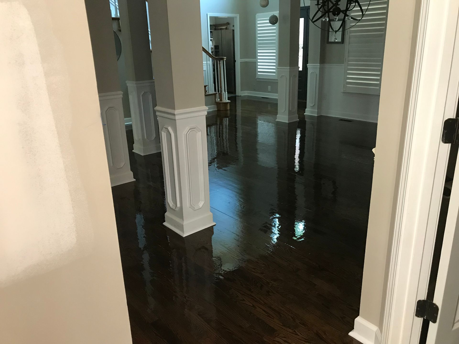 A hallway in a house with hardwood floors and white trim.