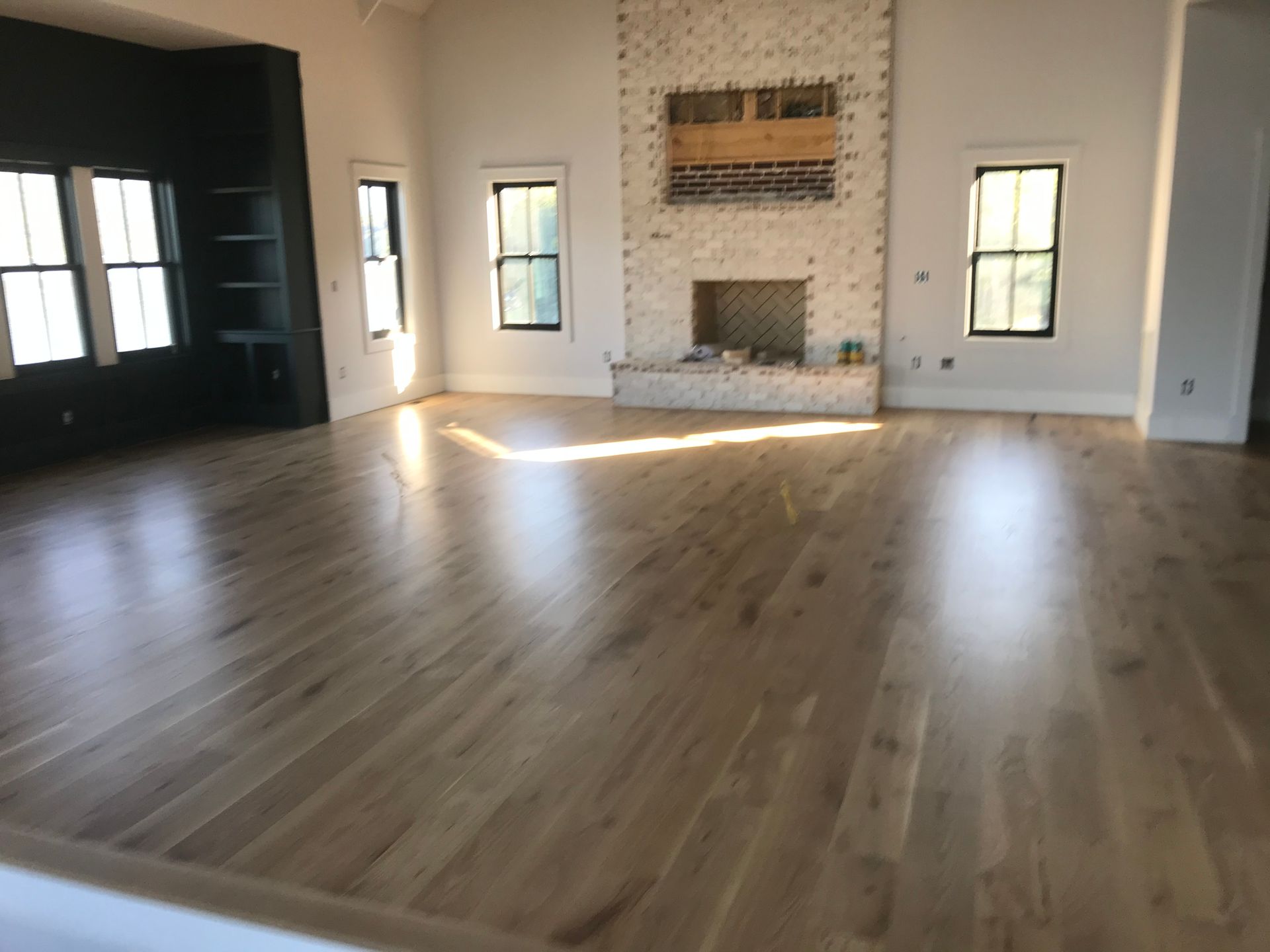 A living room with hardwood floors and a fireplace