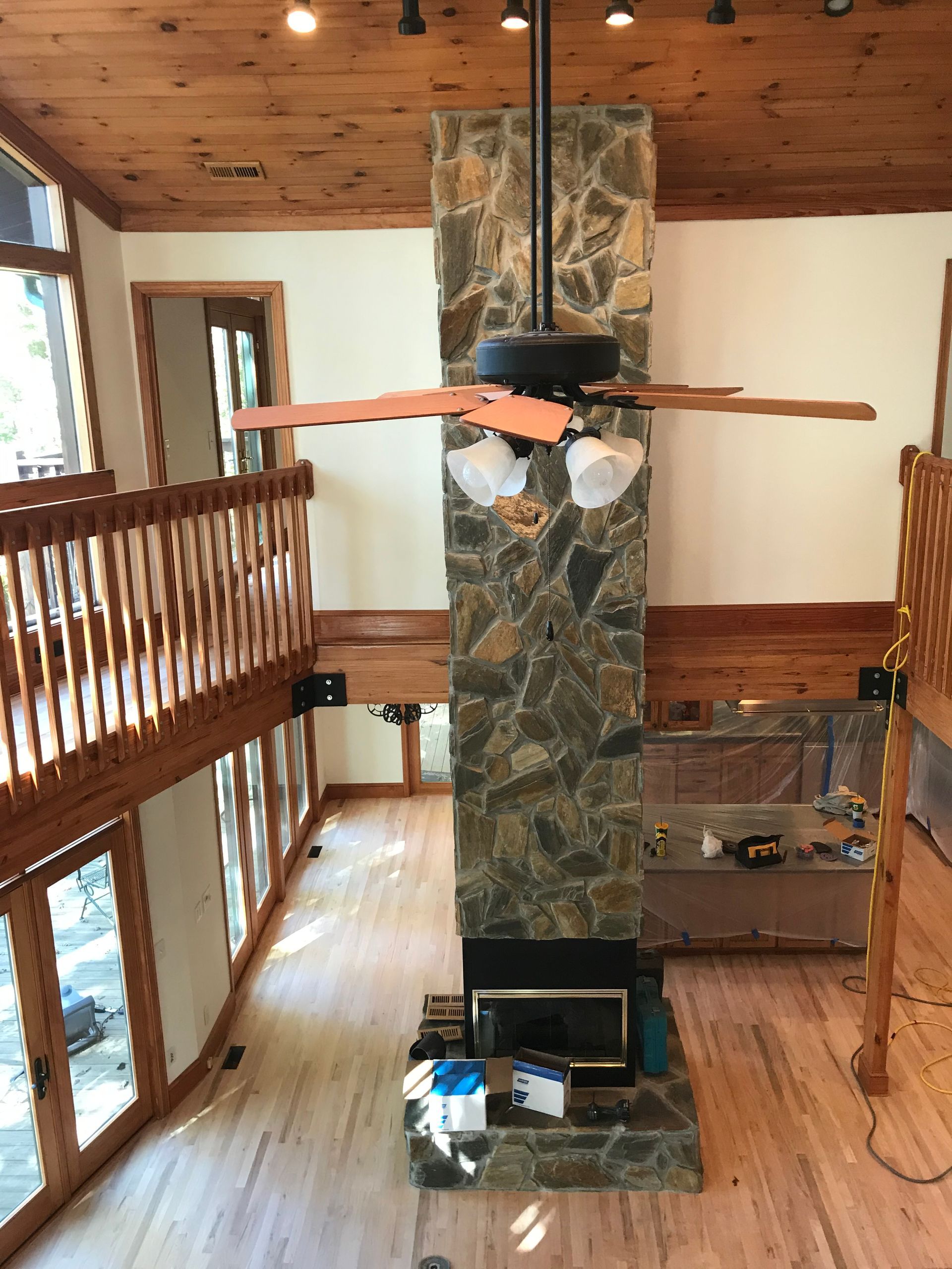 A living room with a fireplace and a ceiling fan