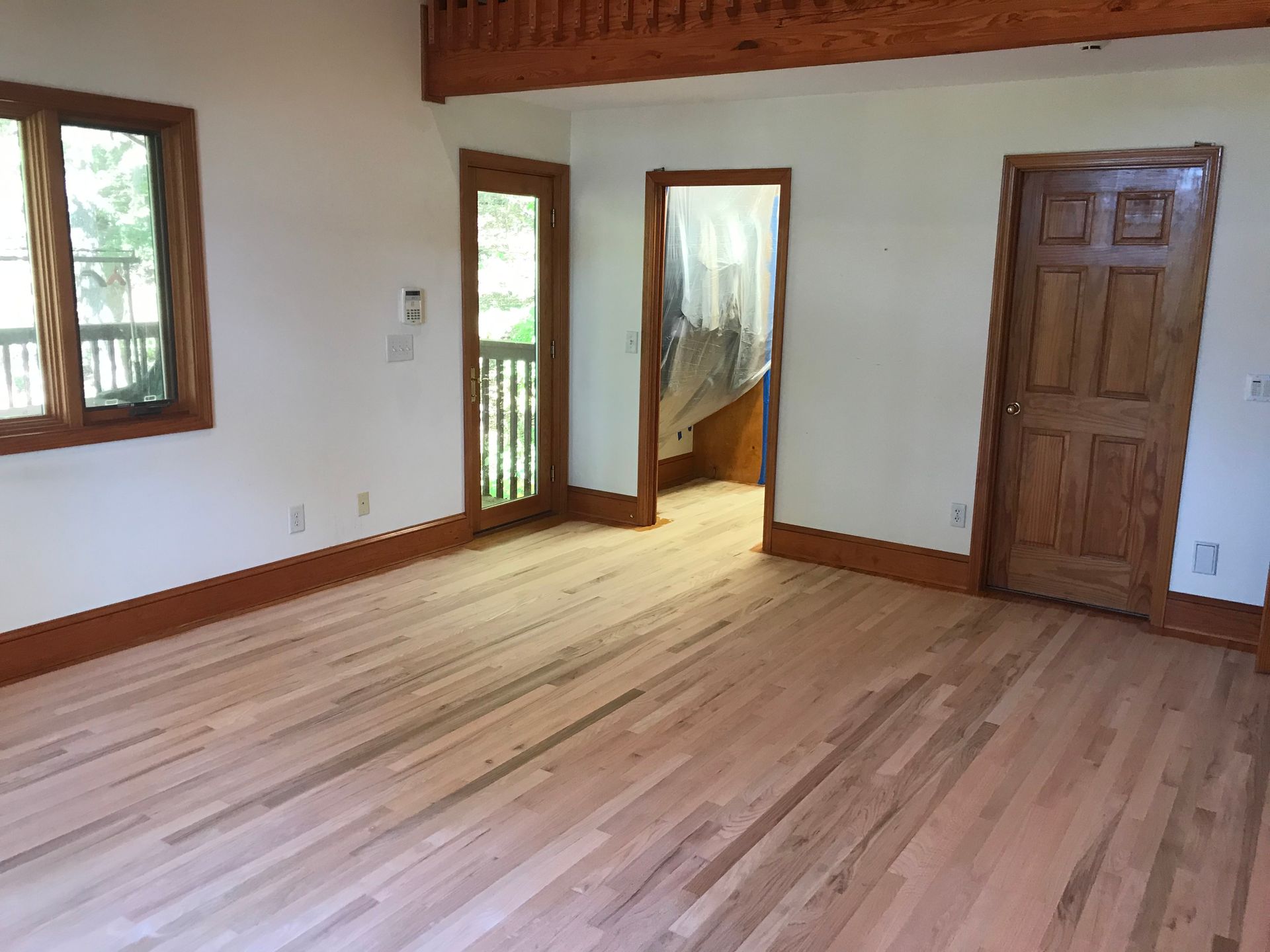 An empty room with hardwood floors and white walls.