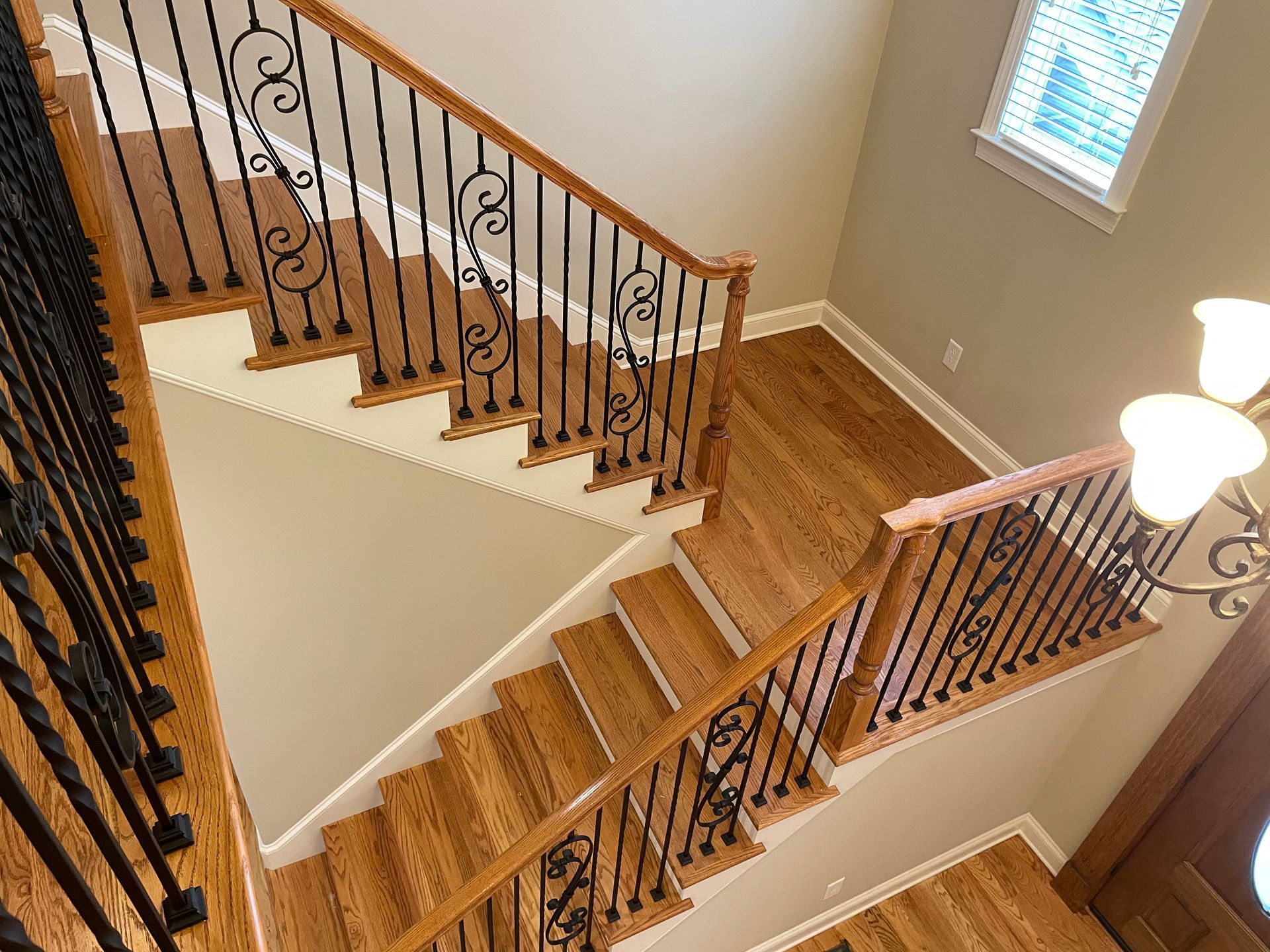 A wooden staircase with a wrought iron railing in a house.