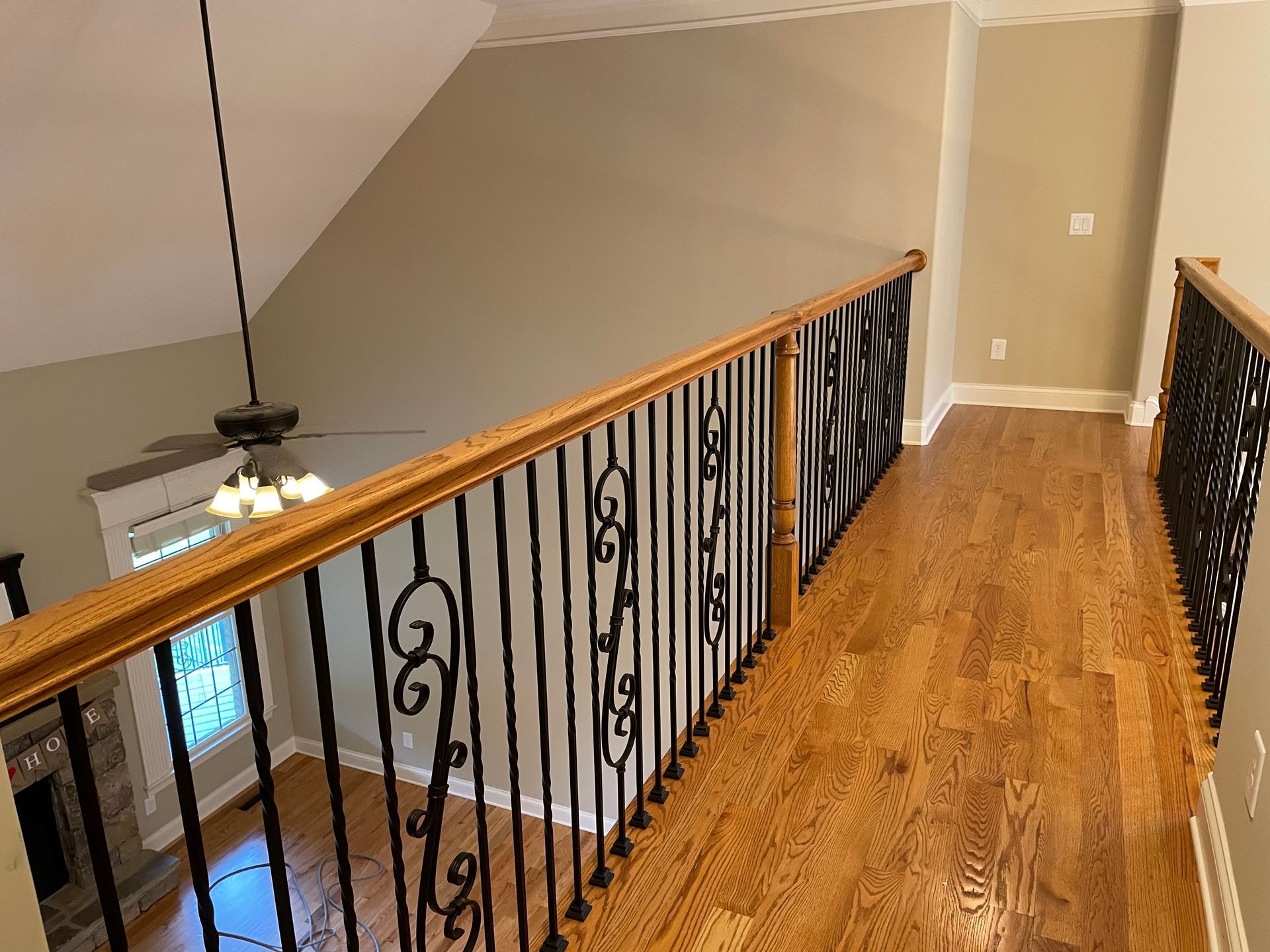 A staircase with a wrought iron railing and hardwood floors in a house.