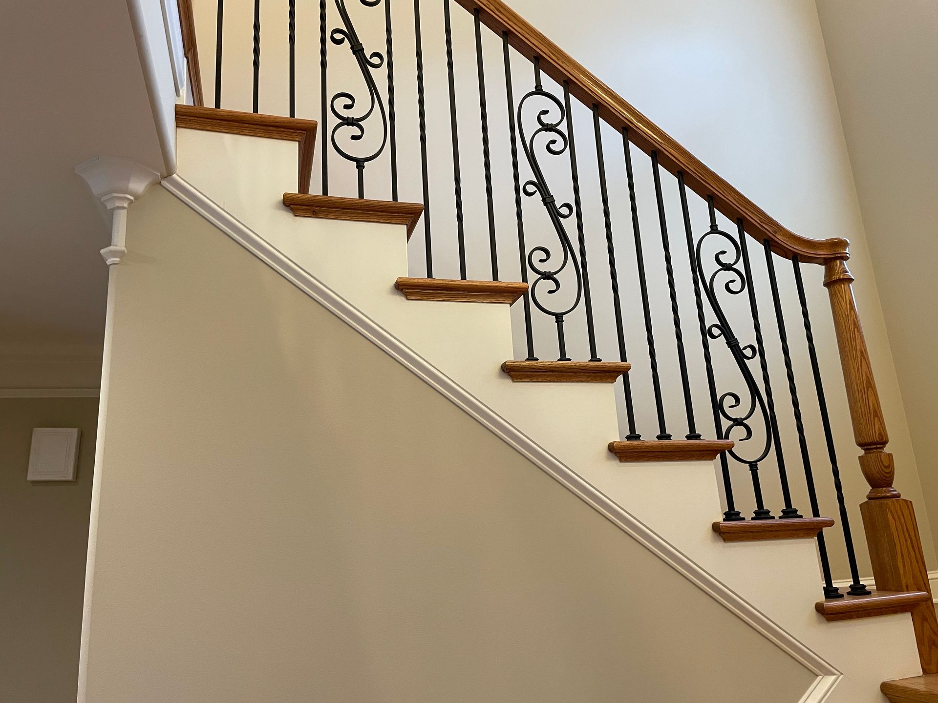 A staircase with a wrought iron railing and wooden steps in a house.
