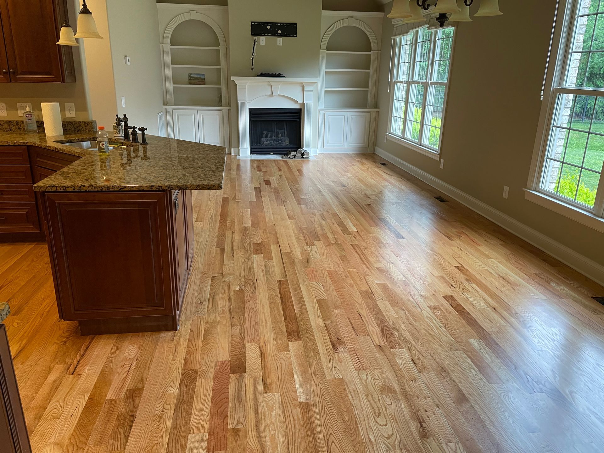 A living room with hardwood floors and a fireplace.