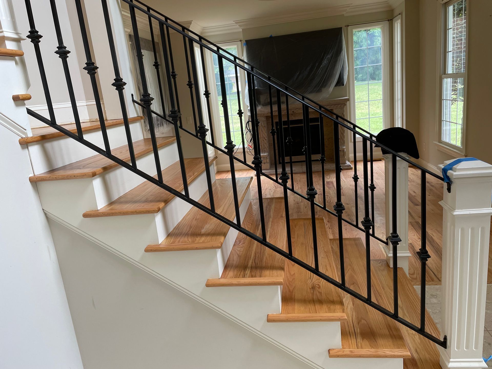 A staircase with a wrought iron railing and wooden steps in a house.