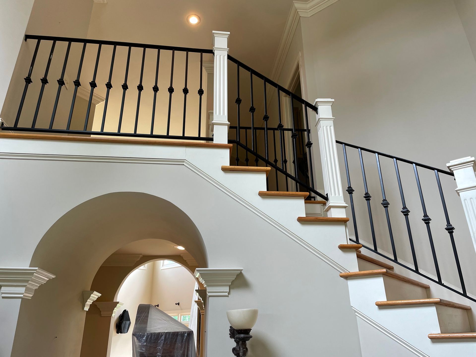 A staircase with a wrought iron railing and wooden steps