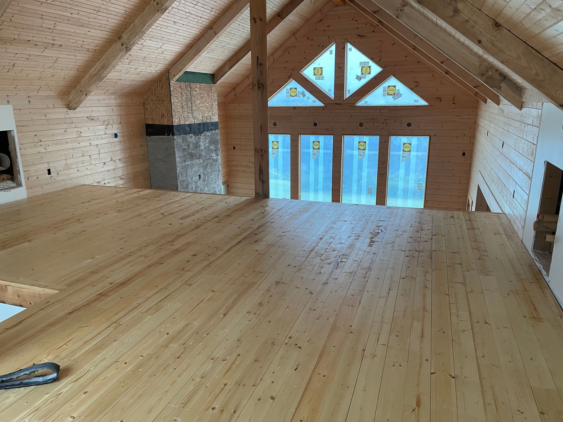 An empty room with a wooden floor and a large window