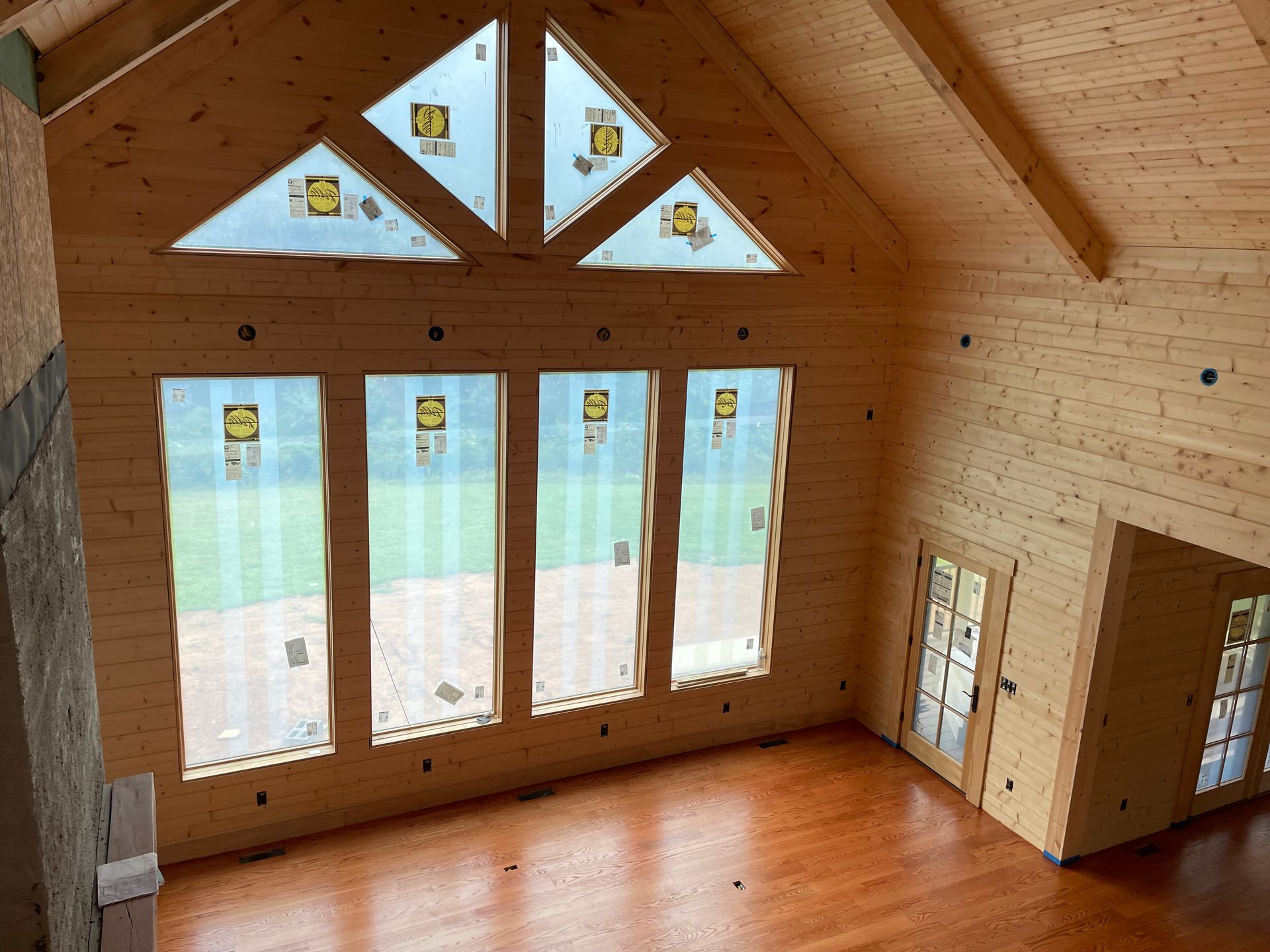 A large wooden room with lots of windows and a vaulted ceiling