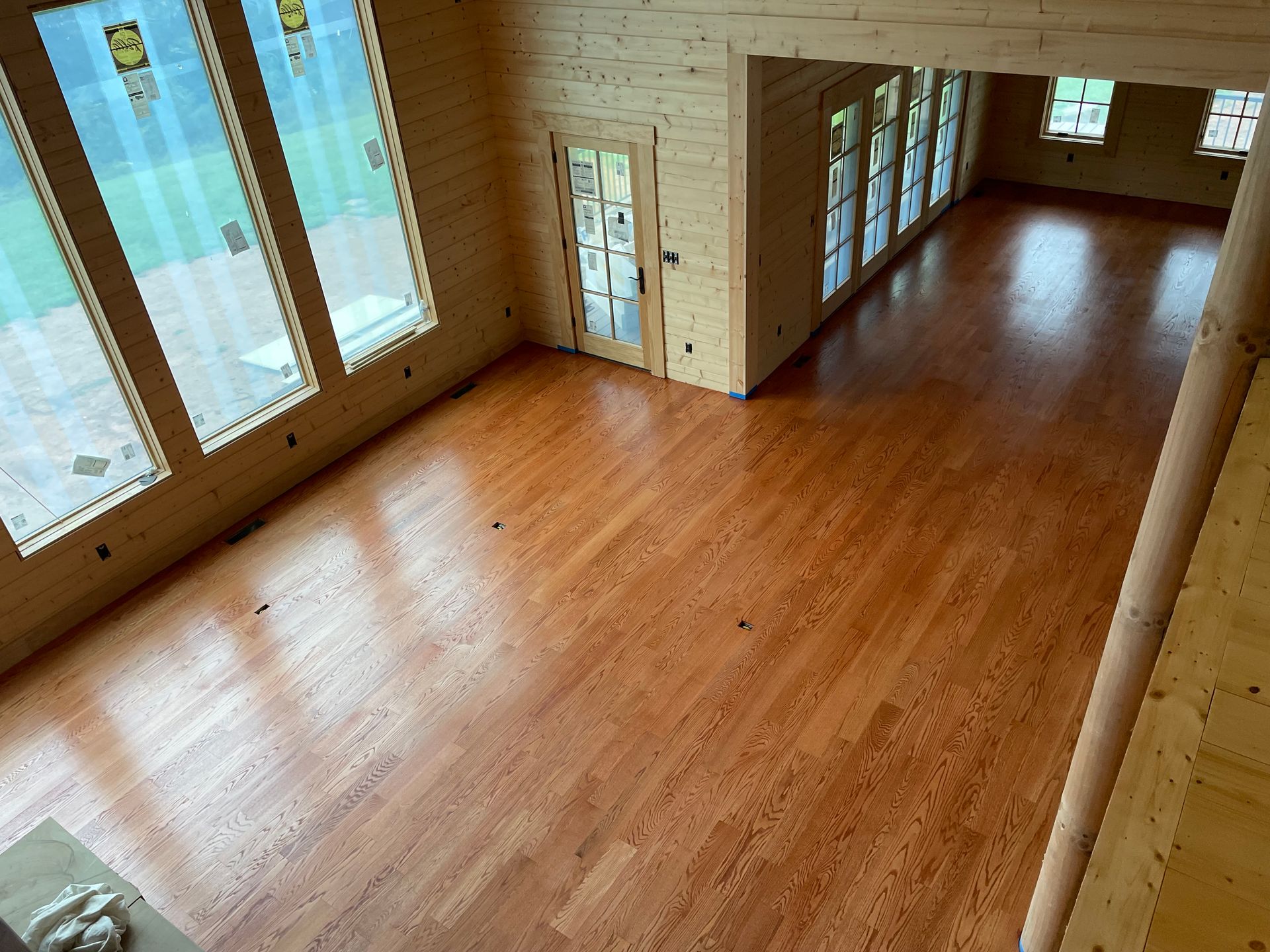 A large room with hardwood floors and lots of windows