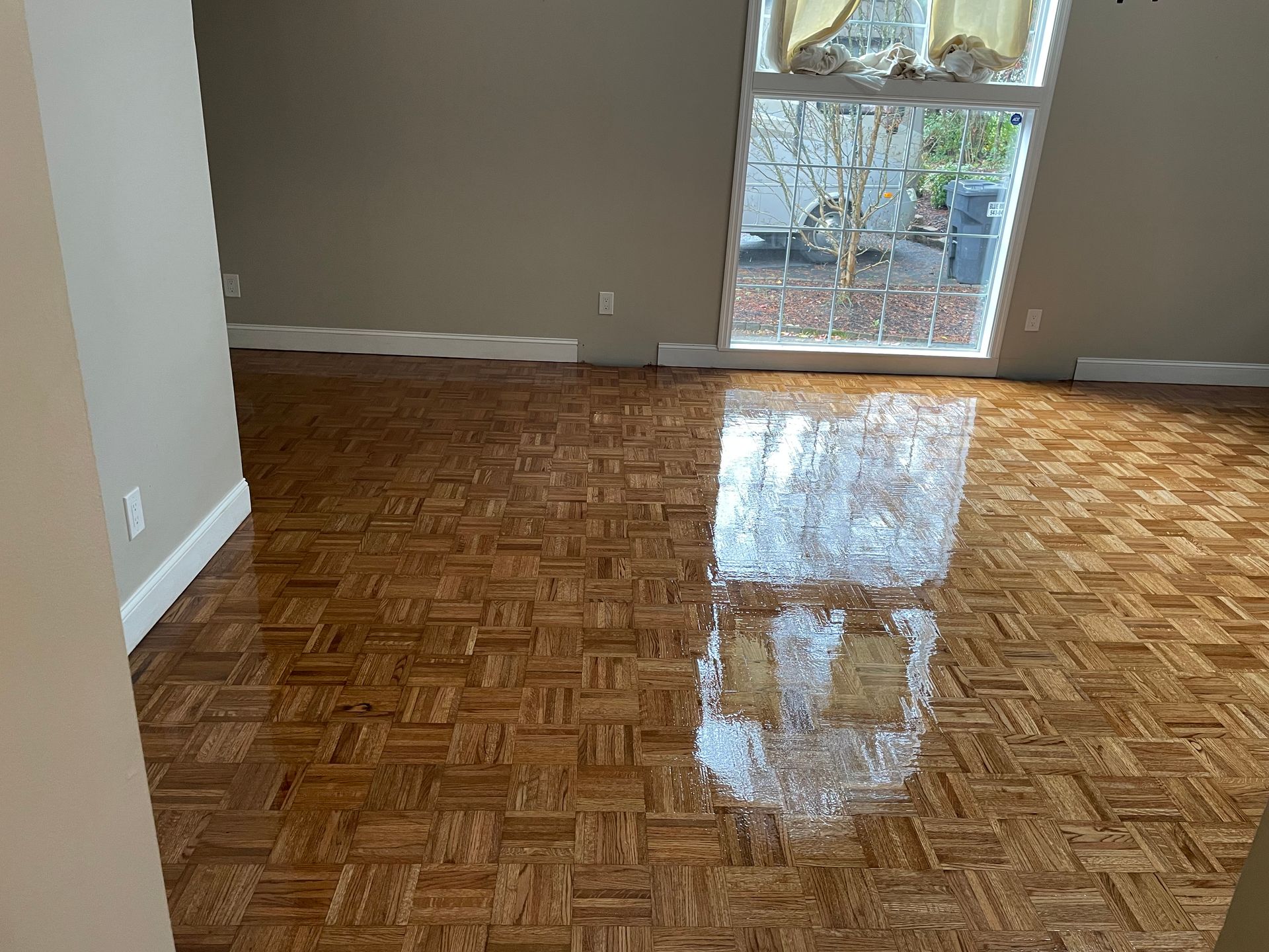 A living room with a wooden floor and a window.