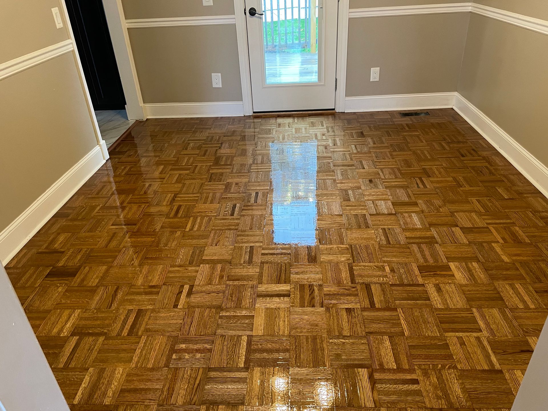 A living room with a wooden floor and a sliding glass door.
