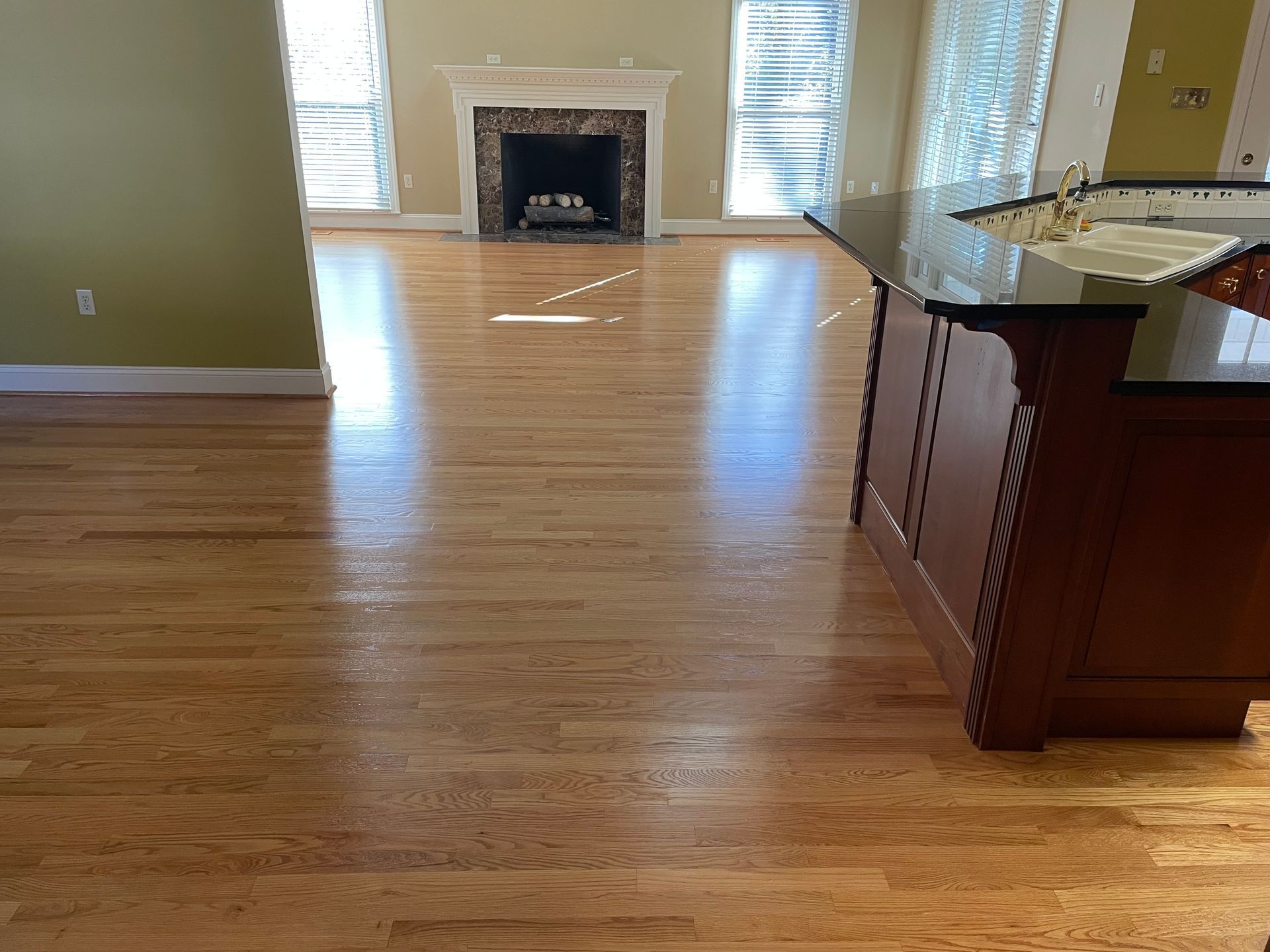A living room with hardwood floors and a fireplace.