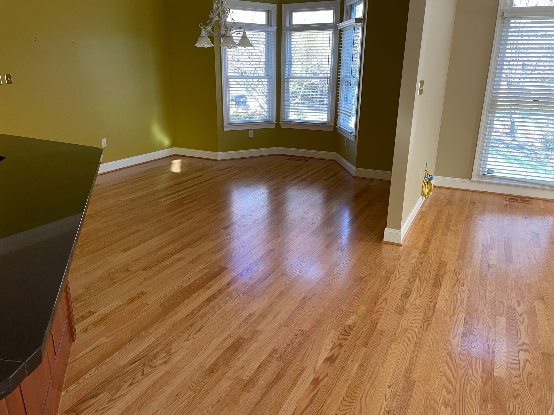 An empty living room with hardwood floors and yellow walls.