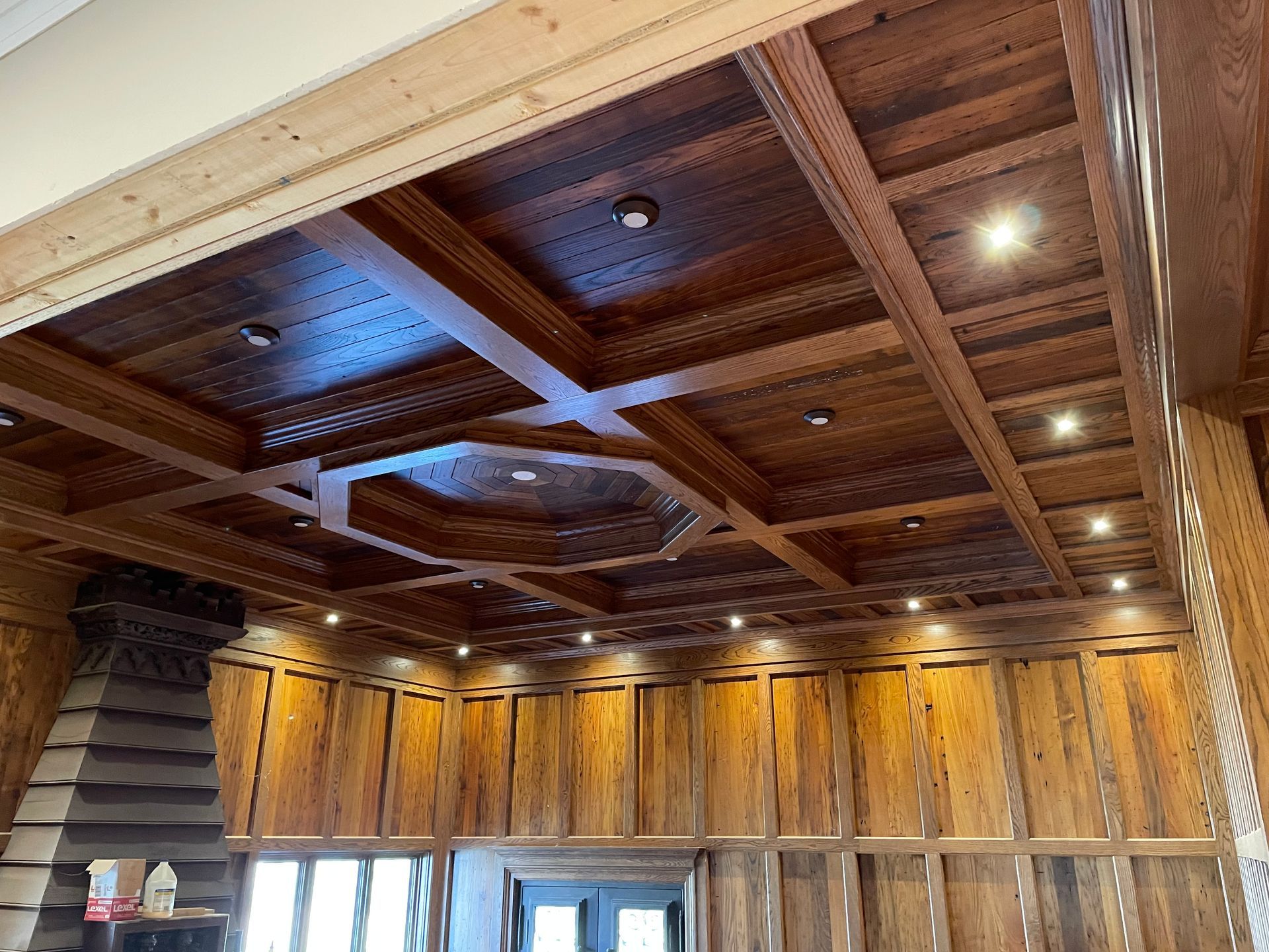 A room with a wooden ceiling and a fireplace.