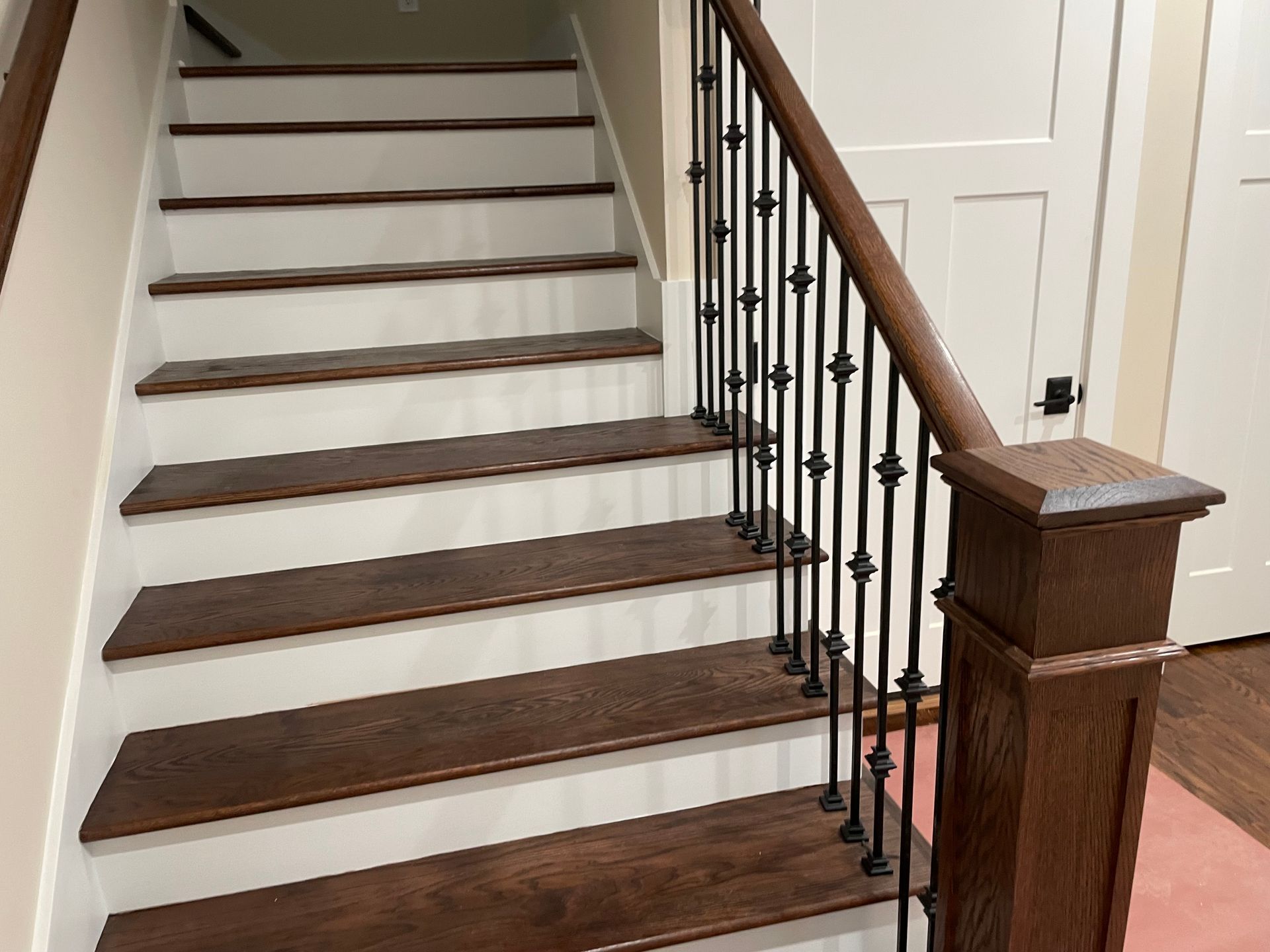 A set of stairs with wooden steps and a wrought iron railing.
