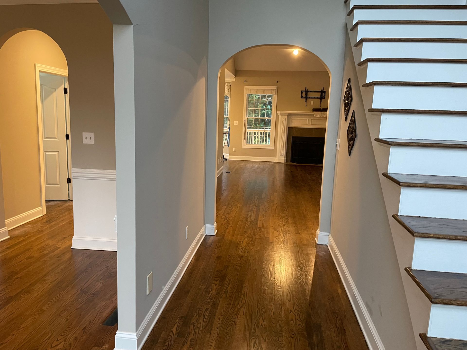 A hallway with hardwood floors and stairs in a house