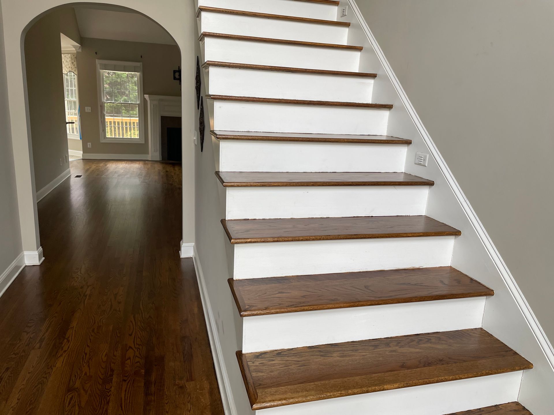 A staircase in a house with white steps and wooden steps