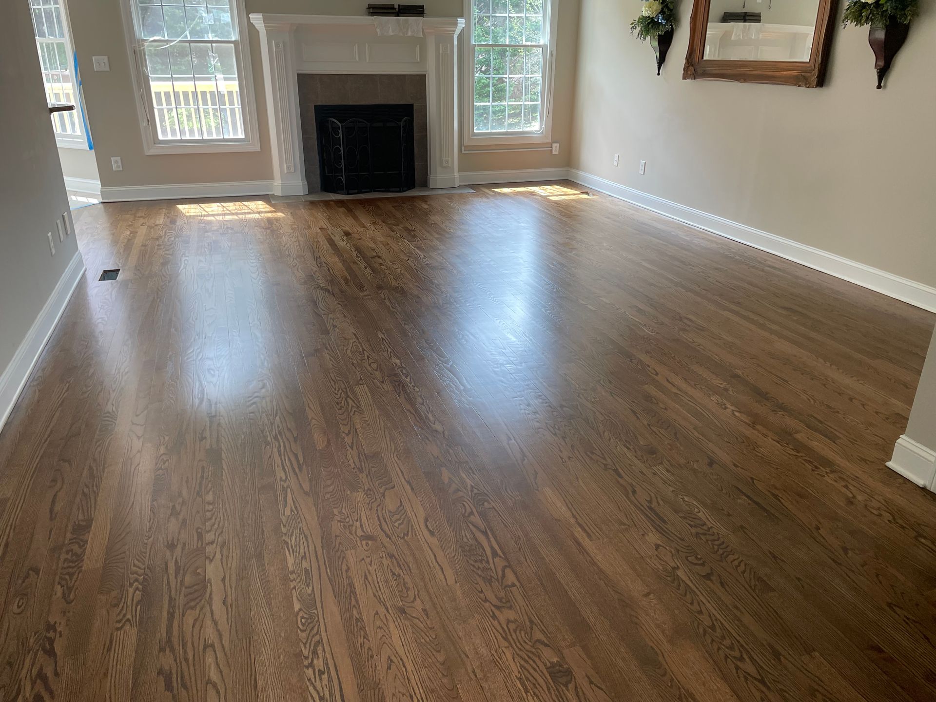 A living room with hardwood floors and a fireplace.
