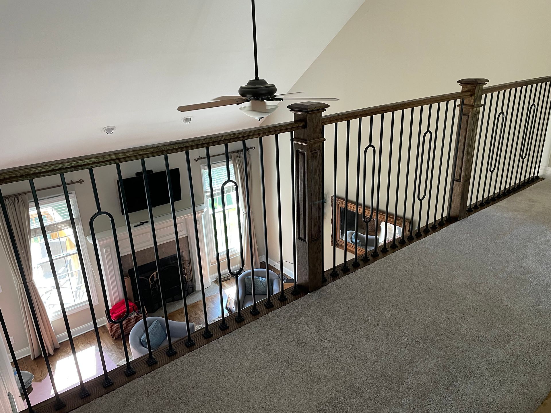 A view of a living room from a balcony with a ceiling fan.