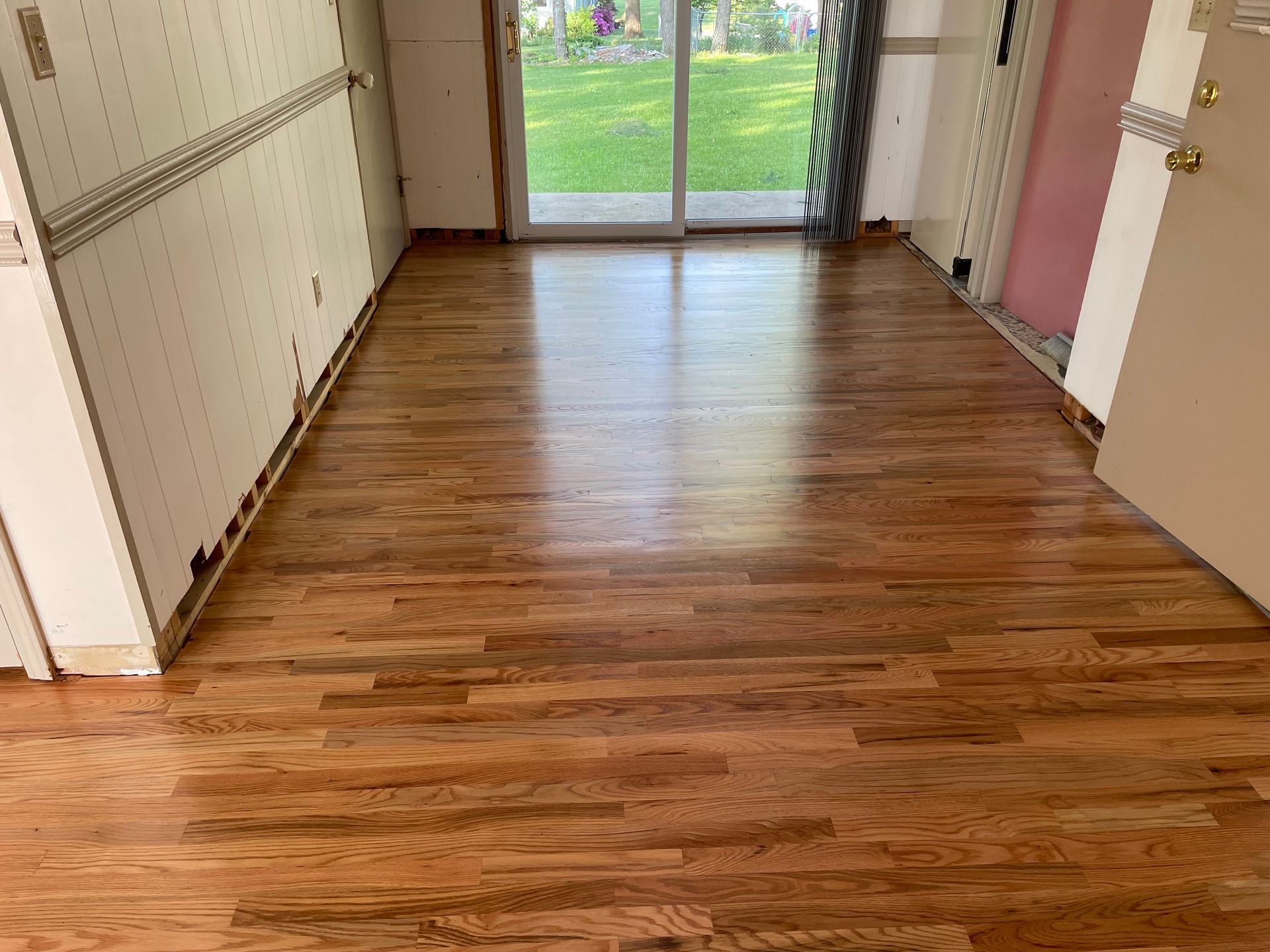 A room with a wooden floor and a sliding glass door.