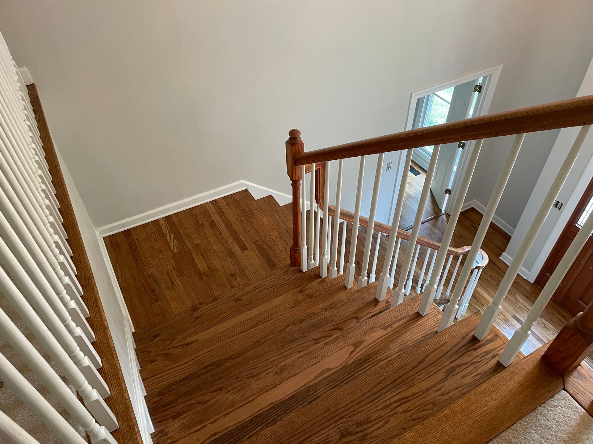 A wooden staircase with a white railing in a house.