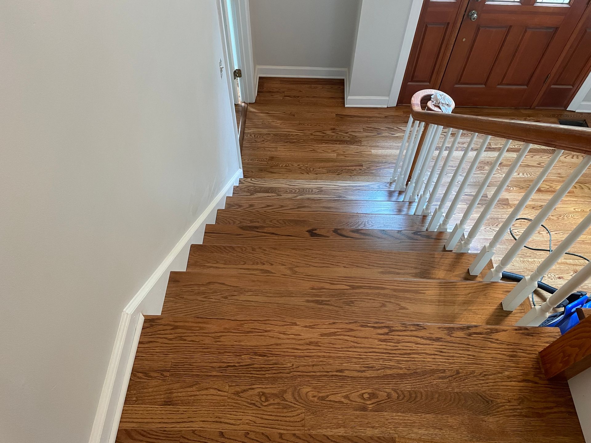 A wooden staircase with a white railing in a house.