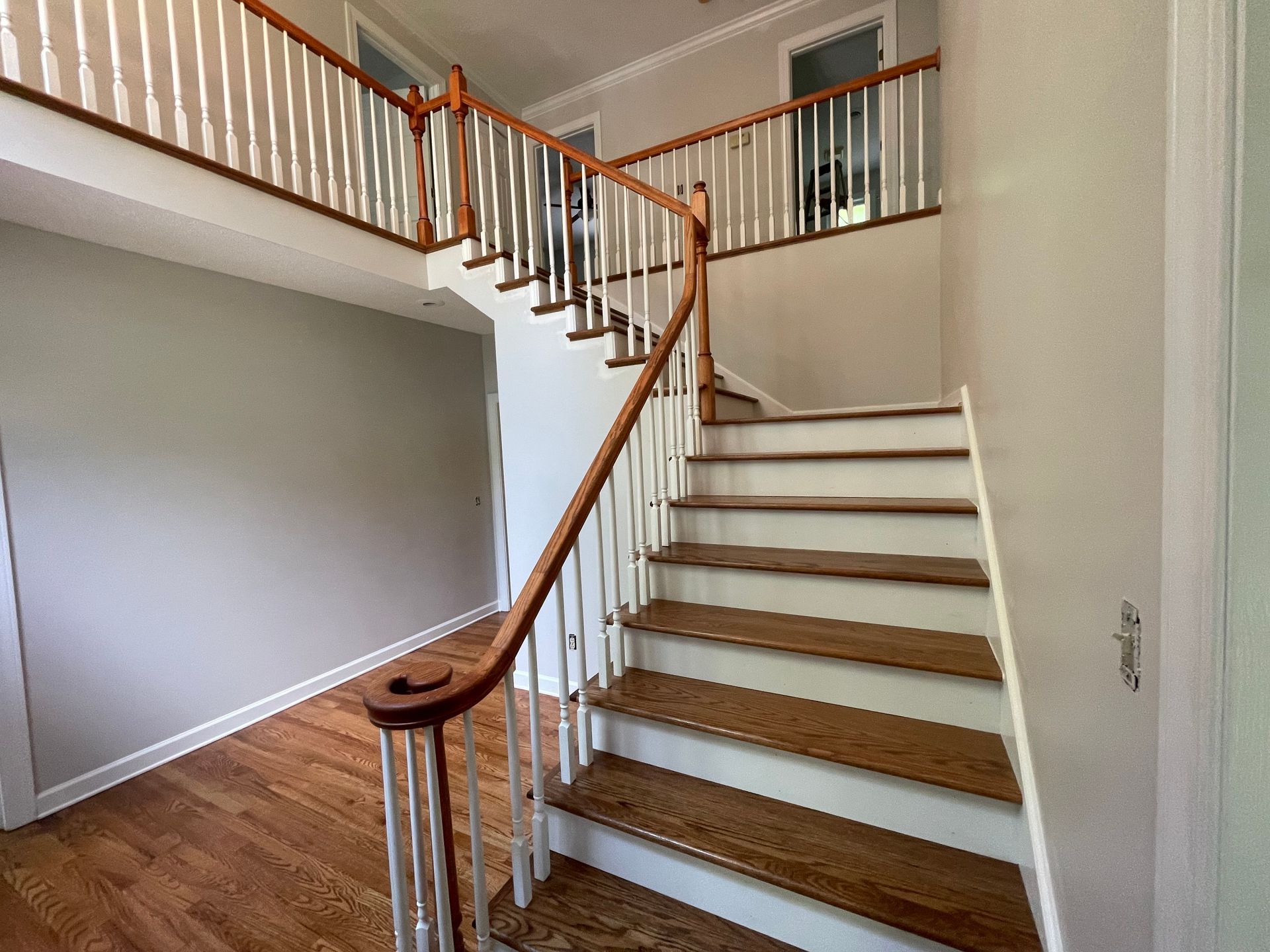 A staircase with wooden steps and a white railing in a house.