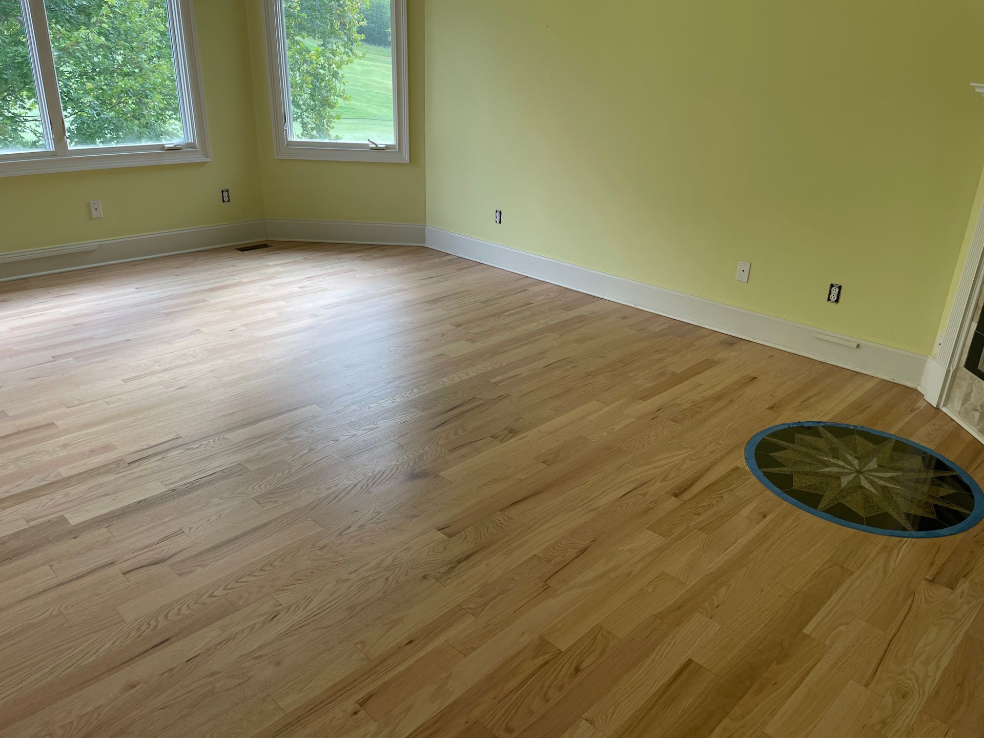 A living room with hardwood floors and yellow walls.