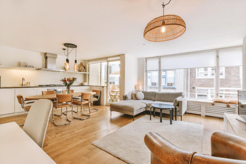 Una sala de estar con un sofá, sillas, una mesa y una lámpara.