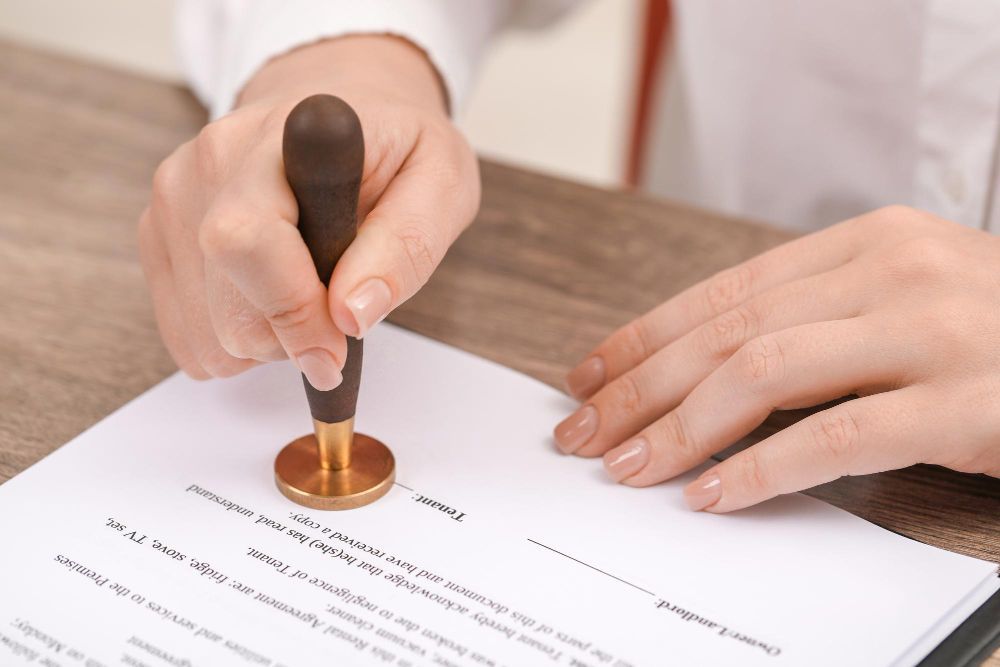 Una mujer está sellando un documento con un sello de lacre.