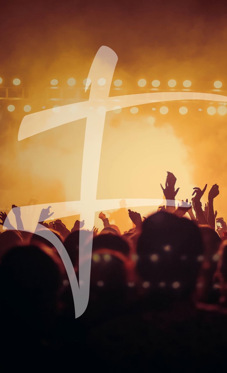 Een grote menigte met opgeheven handen bij een concert; een oplichtend kruis is eroverheen geprojecteerd.