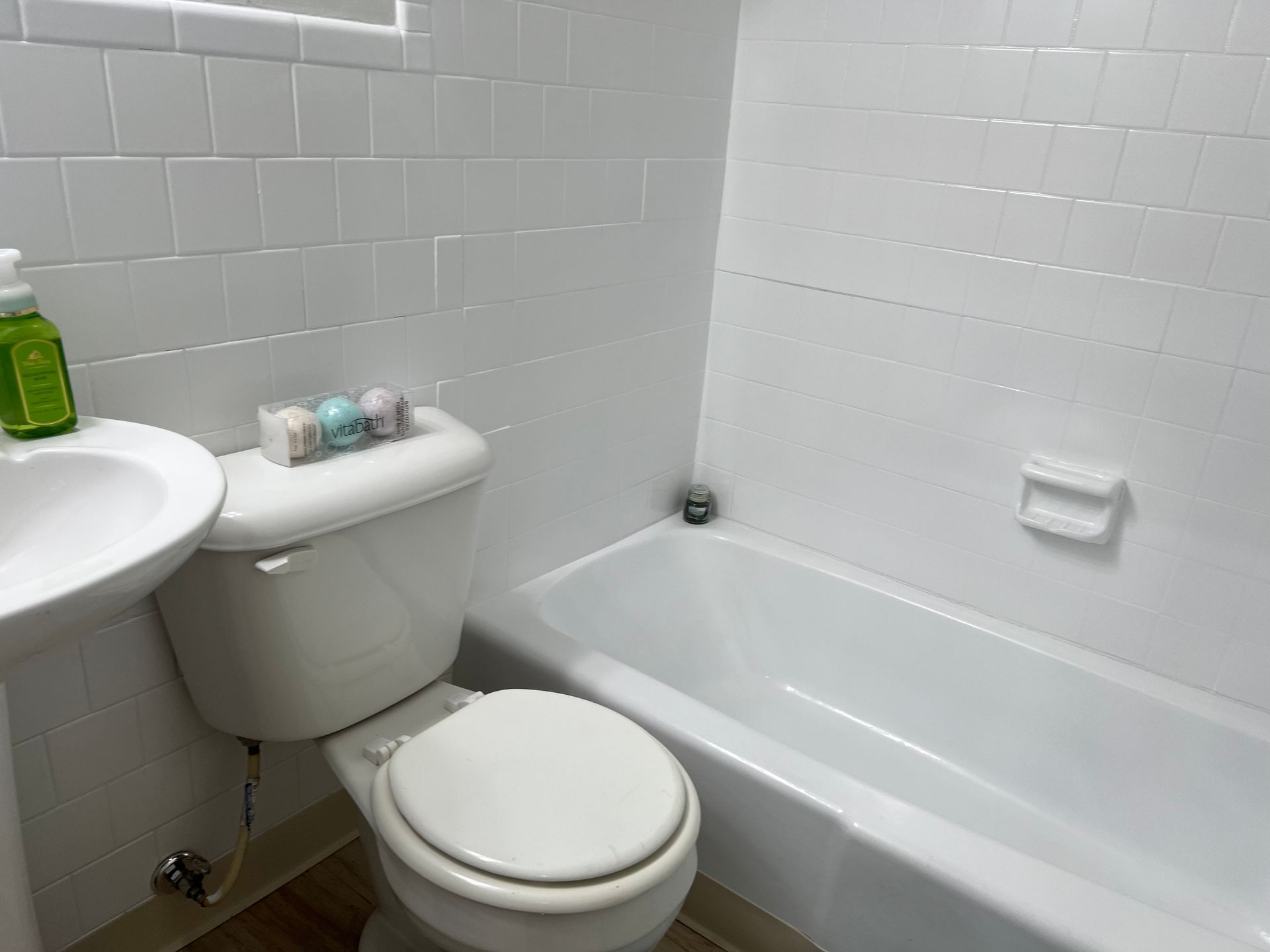 A bathroom with a toilet , sink and bathtub.