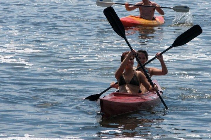 A man and a woman are paddling kayaks in the water