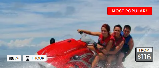 A group of people are riding a red jet ski.