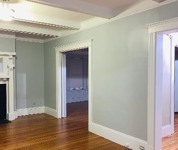 An empty living room with hardwood floors and a fireplace.