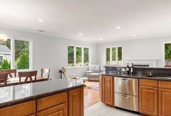 A kitchen with stainless steel appliances , granite counter tops , and wooden cabinets.