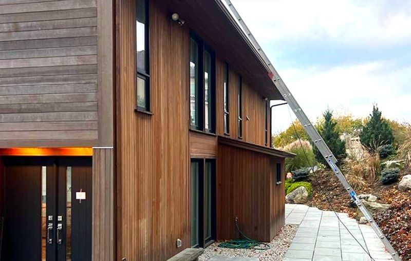 A large wooden house with a ladder attached to the side of it.