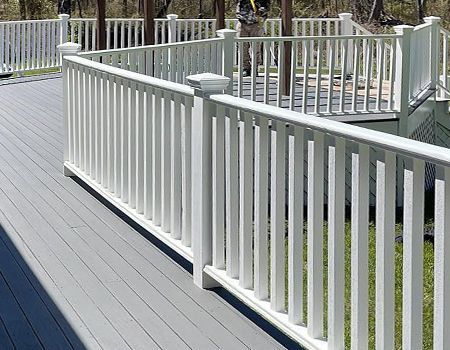 A white fence surrounds a wooden deck.