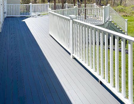 There is a blue deck with a white railing.