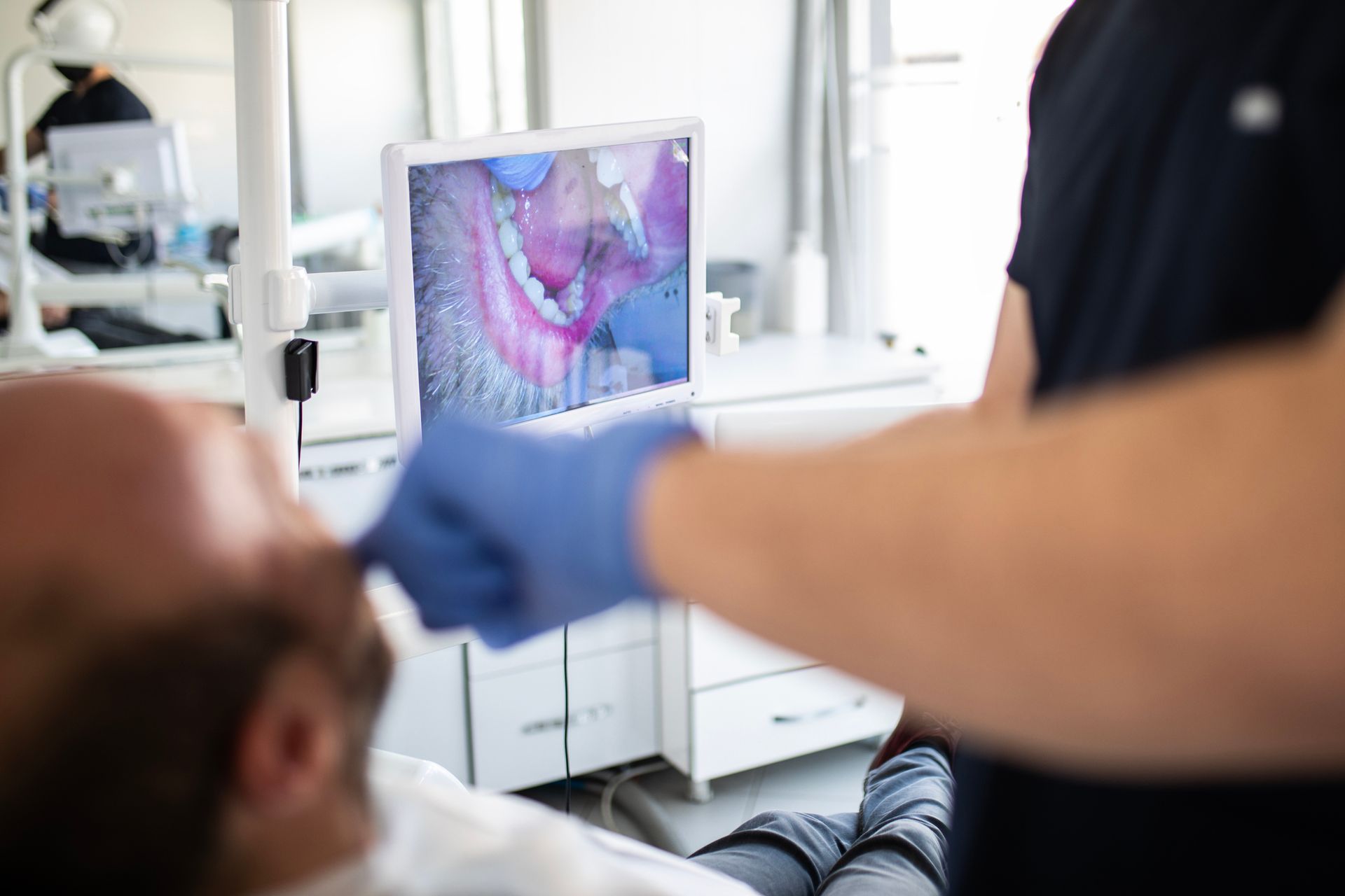 Dentist using digital imaging to examine a patient's mouth.