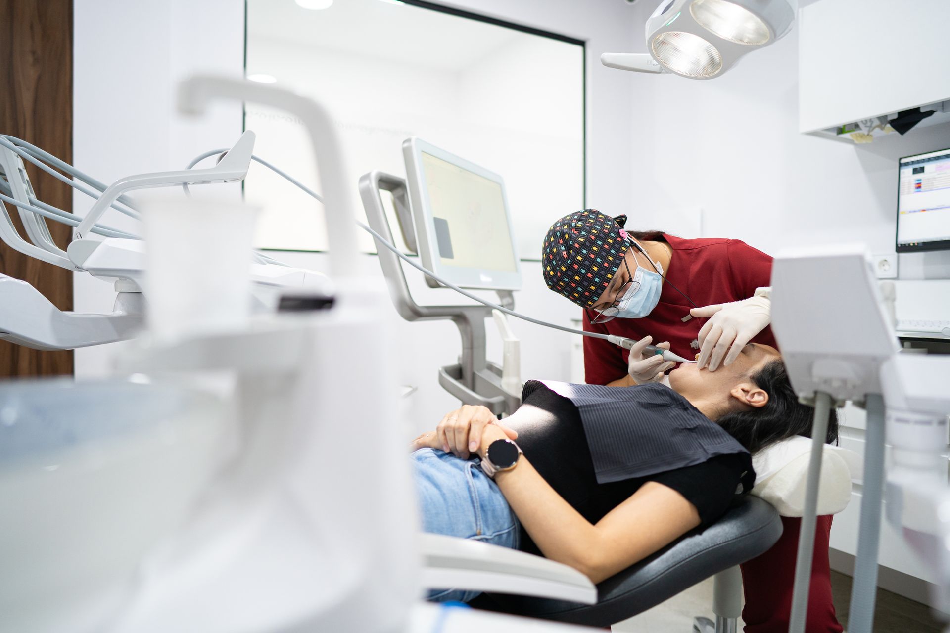 Dentist examining a patient's teeth in a modern dental office.