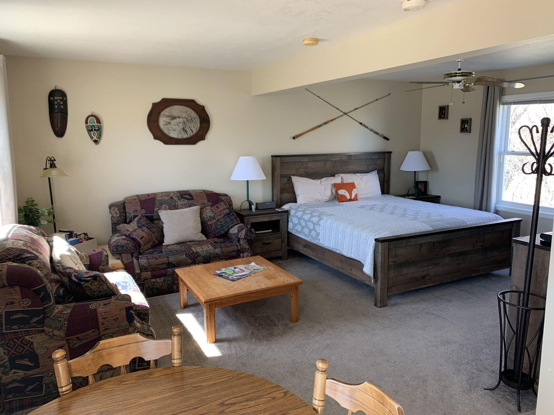 A living room with a bed , couch , table and chairs.