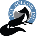 The fox hollow inn logo is a silhouette of a fox in a blue circle.