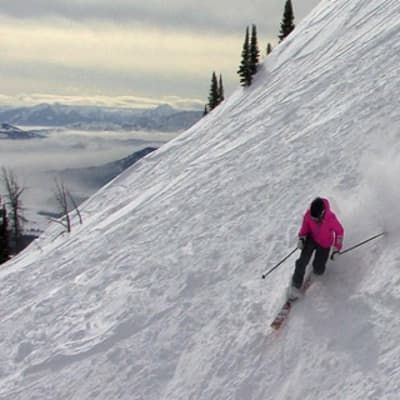 A person is skiing down a snow covered slope.