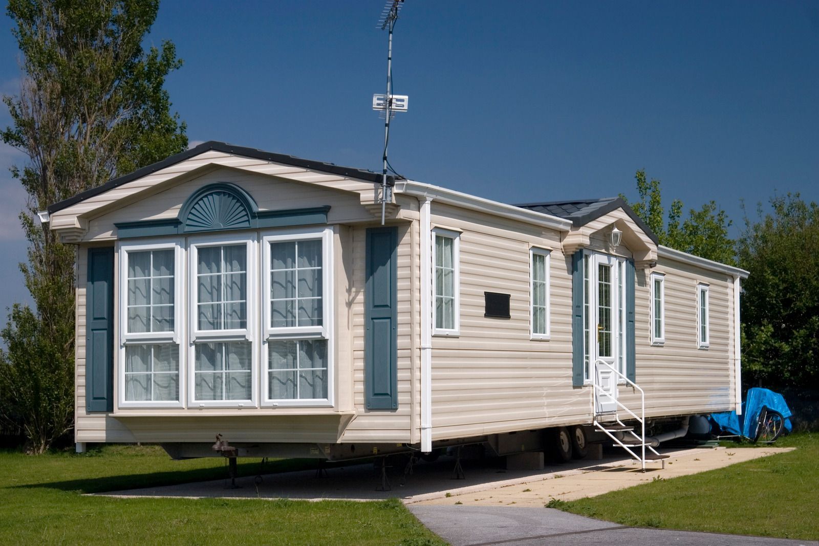 A mobile home is parked in a grassy field.