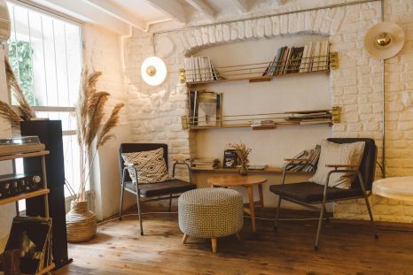 A living room with chairs , a table , and a bookshelf.