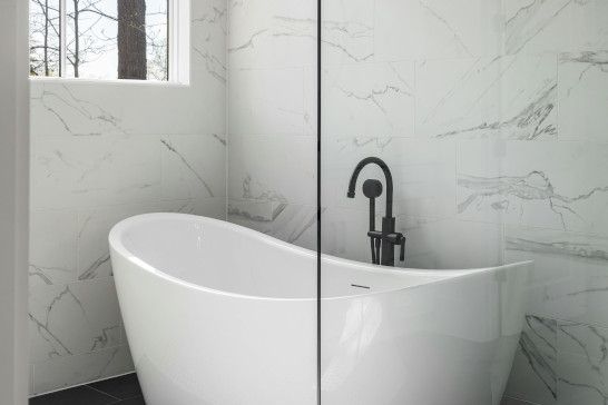 A bathtub, washbasin, and toilet seat with a shower curtain.