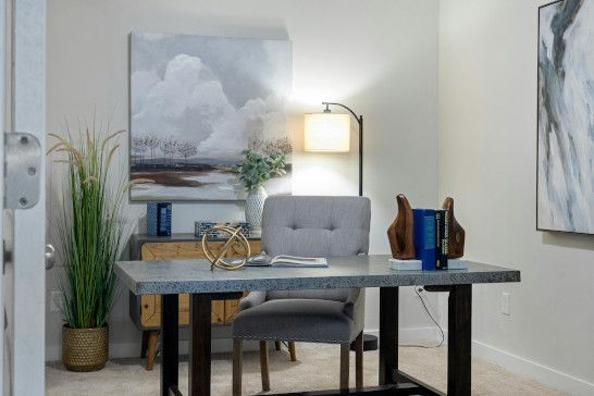 A desk with a dining table, table lamp, and sewing machine.