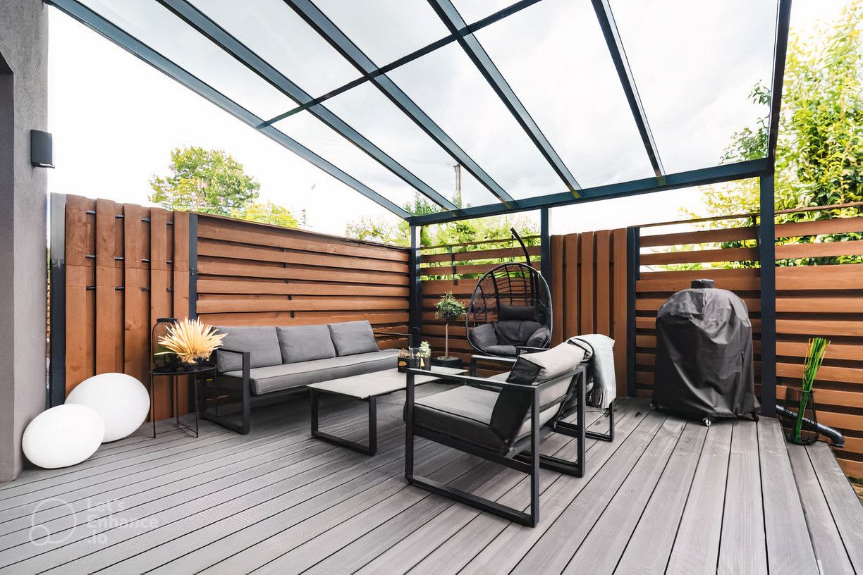 A patio with a couch , chairs and a table under a canopy.