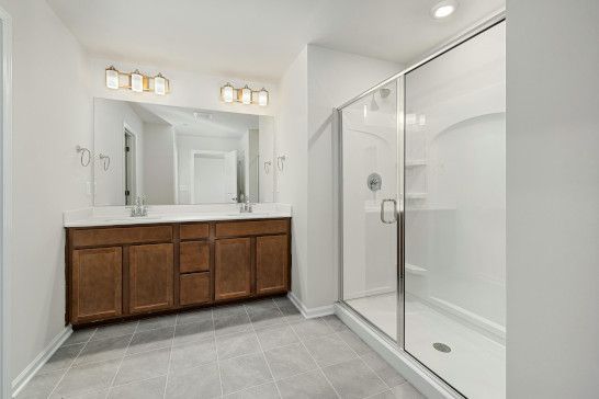 A medicine chest near a washbasin, bathtub, microwave, and tub.